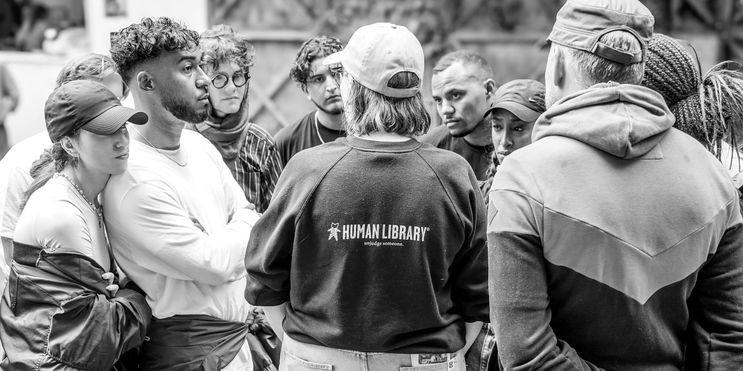 A librarian talking with interested readers about the opportunity to borrow a person as an open book.